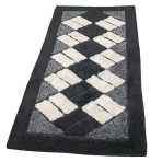 Teppich „Black Diamond Mosaic Rug“, 70x140 cm. Schwarzer teppich, verziert mit cremefarbenen rechtecken in dynamischen diagonalen reihen.